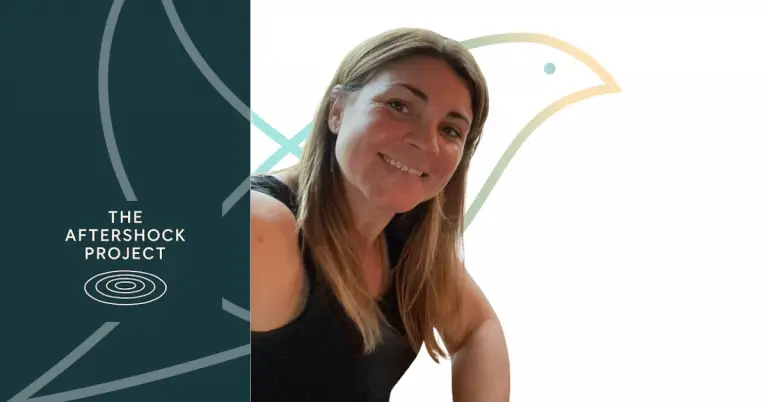 A rectangular graphic featuring Sue Oatley smiling at the camera. She has long light brown hair and is wearing a black sleeveless top. The background on the right is white with a large, pale outline of the Lark bird logo in soft teal and golden yellow. On the left is a dark teal panel with the text “The Aftershock Project” in white above a simple ripple-style circular icon. Subtle grey lines from the Lark logo extend across both sides of the design.